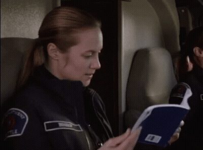 Police Woman On Plane Holding Folder GIF
