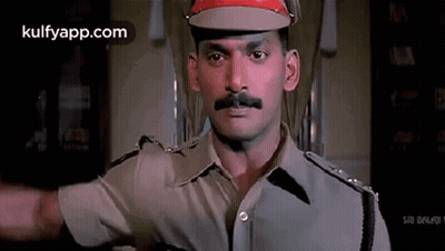 Policeman In Red Hat And Mustache Standing In Room GIF