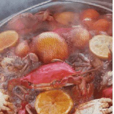 Pot Of Food With Crabs And Lemon Slices GIF