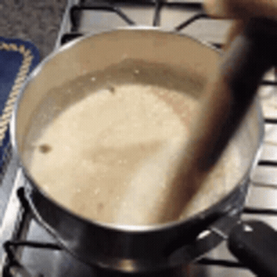 Pot Of Liquid Stirred With Wooden Spoon On Stove GIF