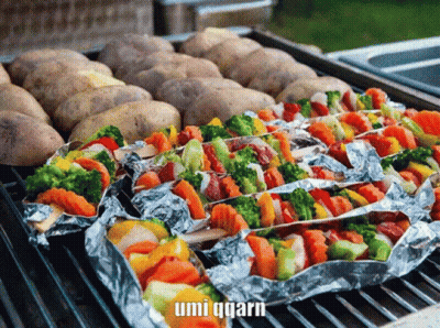 Potatoes And Vegetables Wrapped In Aluminum Foil On A Grill With Umi Qqarn In The Corner GIF