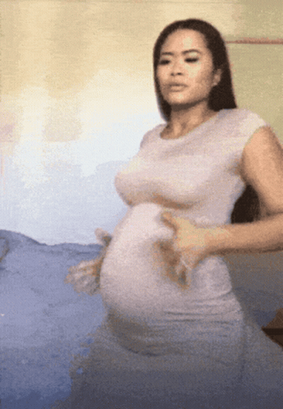 Pregnant Woman In White Dress On Bed GIF