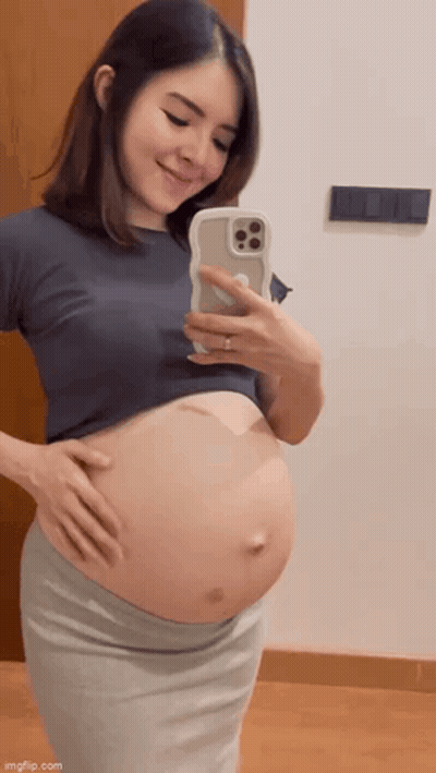 Pregnant Woman Taking Belly Selfie GIF