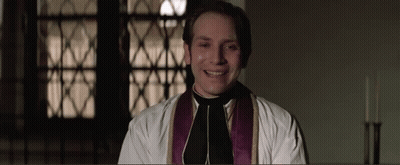 Priest In White Robe And Purple Vest Smiling GIF