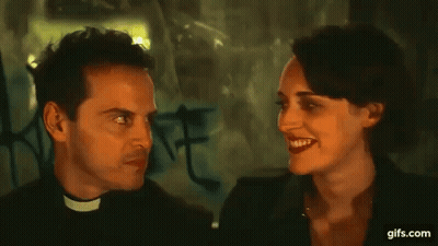 Priest Making Funny Face Talking To Woman In Dark Room GIF