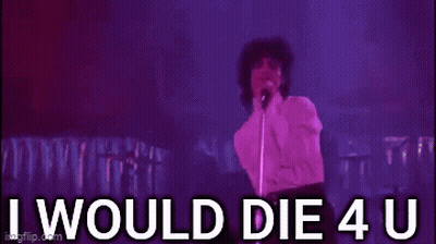 Prince Is Standing In Front Of A Microphone On A Stage And Singing . GIF