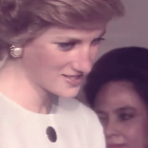 Princess Diana Is Wearing A White Dress And Earrings While Standing Next To A Woman . GIF