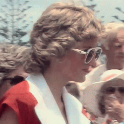 Princess Diana Is Wearing Sunglasses And A Red And White Jacket . GIF