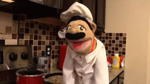 Puppet In Chef Hat Standing In Kitchen GIF