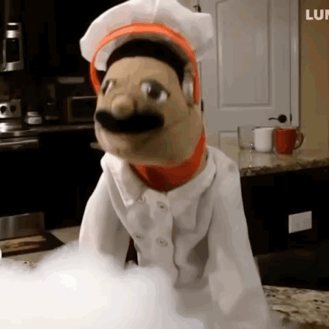 Puppet In Chef Outfit On Counter GIF