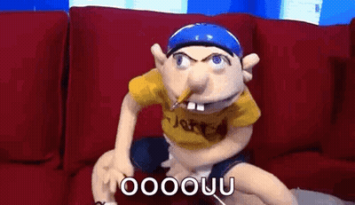 Puppet Sitting On Couch With Pencil In Mouth GIF