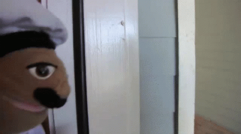 Puppet Wearing Chef Hat Looking Out Door GIF