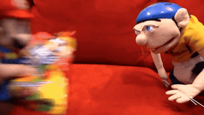 Puppet With Blue Helmet Sitting On Red Couch Next To Another Puppet GIF