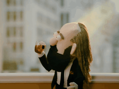 Puppet With Dreadlocks And Beard Drinking From Glass GIF