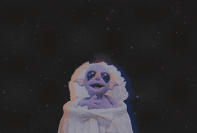 Purple Cartoon Character Sitting In Crib GIF