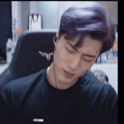 Purple Haired Man Sitting in Chair With Headphones