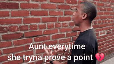 Purple-Haired Woman Behind White Brick Wall With Angry Face In Corner GIF