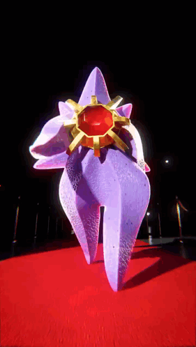 Purple Sculpture With Gold Ring On Red Carpet GIF