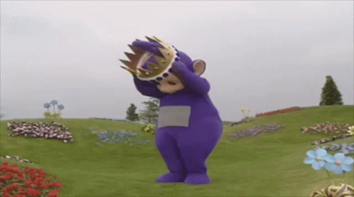 Purple Teddy Bear With Crown In Field Of Flowers GIF