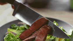 Putting A Sliced Of Meat On A Bowl Of Salad GIF