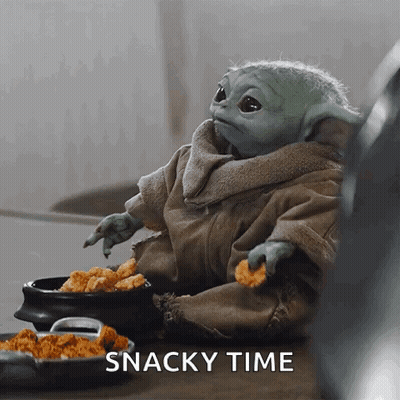 Raccoon Sitting On Wooden Table With Pile Of Food GIF