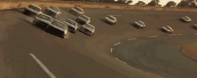 Race Car Driving Down Street With Other Cars GIF