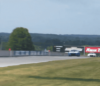 Race Car Going Down Track With Kwik Tire Sign GIF