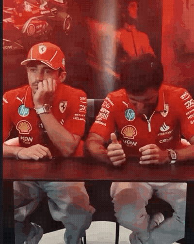 Racing Drivers Sitting With Hands On Faces GIF