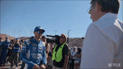 Racing Suit Man Talking To Man In White Shirt Netflix GIF