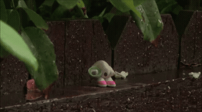 Rain Is Falling On A Wooden Fence With A Leaf In The Foreground GIF