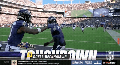 Ravens Players Hugging On Football Field GIF
