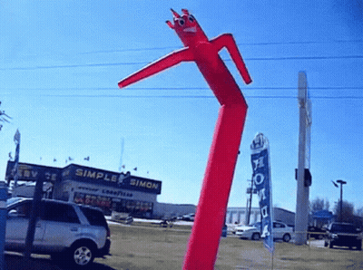 Red Air Dancer In Front Of Simple Simon Building GIF