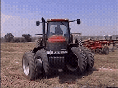 Red And Black Tractor Driving Across Field GIF