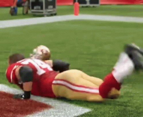Red And Gold Football Player Lying With Legs Up GIF