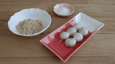 Red And White Plate With Rice Balls On Sticks Next To Rice And Salt Bowls GIF