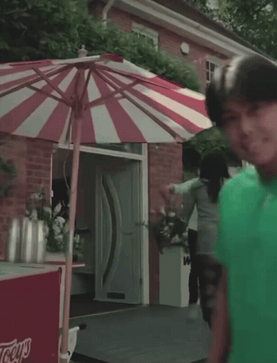 Red And White Striped Umbrella In Front Of Ice Cream Cart That Says Lays GIF