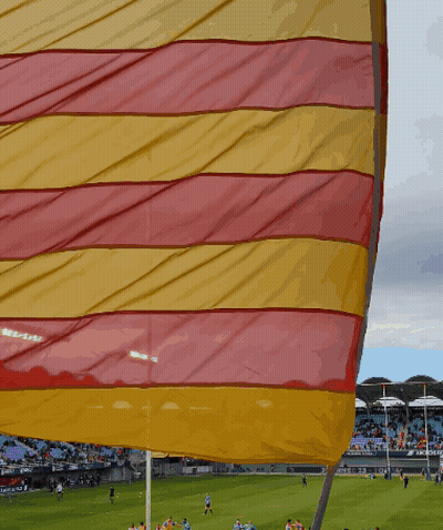 Red And Yellow Flag Flying In Front Of Stadium GIF
