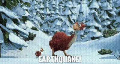 Red Bird Standing In Snow In Front Of Mountain GIF