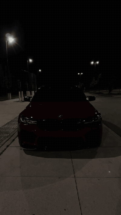 Red BMW Parked On Sidewalk At Night GIF