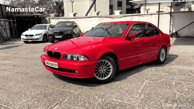 Red BMW Parked With Other Cars Saying Namaste Car GIF