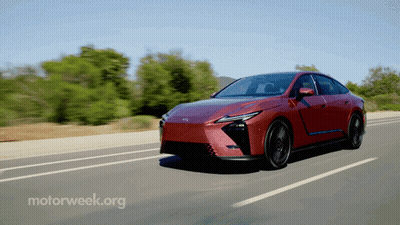 Red Car Driving Down Road With Motorweek.org GIF