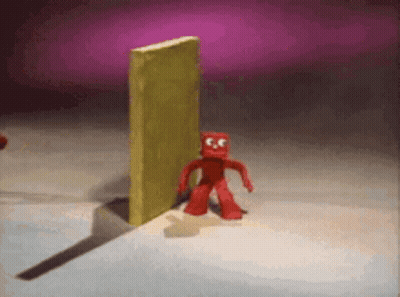 Red Cartoon Character In Front Of Yellow Wall GIF