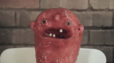 Red Face Statue With Blue Eyes And Teeth GIF