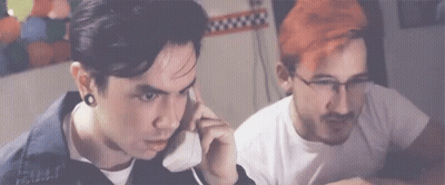 Red Hair Man Talking On Phone Next To Man With Glasses GIF