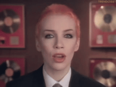 Red Hair Woman In Suit And Tie Before Plaques GIF
