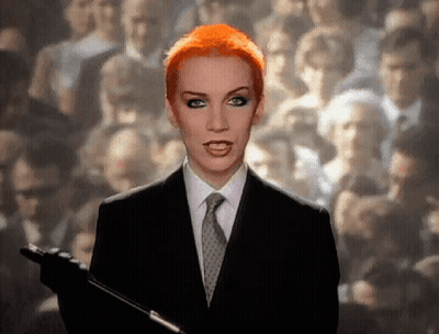 Red Hair Woman In Suit Holding Microphone GIF