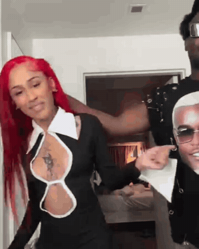 Red Hair Woman Next To Man In Sunglasses And Black Dress GIF