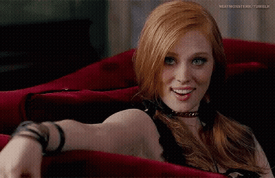 Red-Haired Blue-Eyed Woman On Red Couch GIF