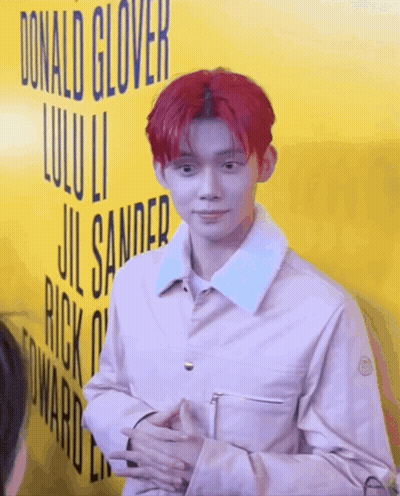 Red-Haired Man In Front Of Yellow Donald Glover Sign GIF