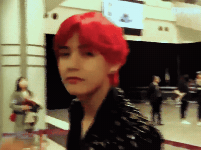 Red-Haired Man Standing In Front Of Sign Saying A GIF
